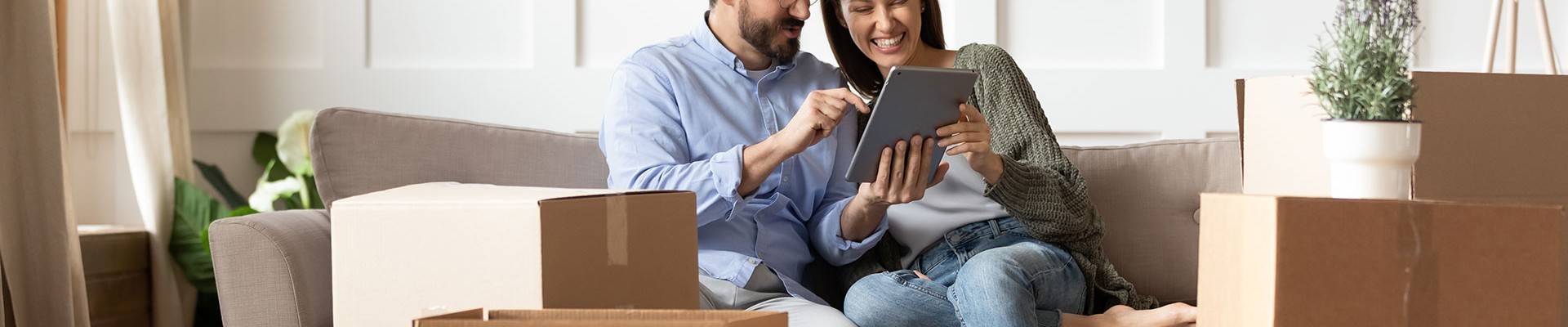 Couple On The Sofa In Thier New Home With Ipad