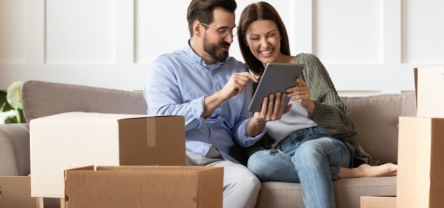 Couple On The Sofa In Thier New Home With Ipad