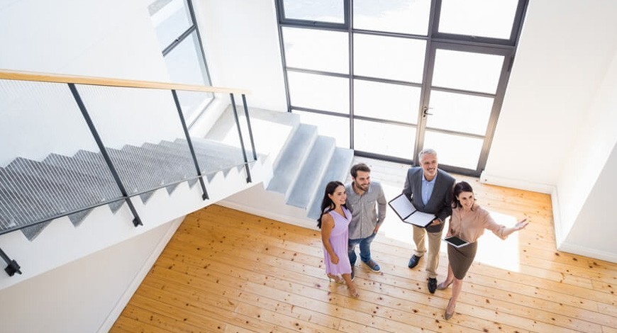 Couple Looking At House Features With Estate Agents Mobile